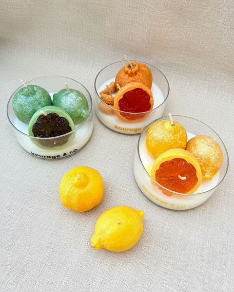 Candle set shaped like fruits on a textured fabric background