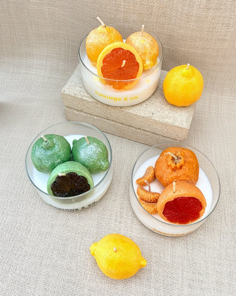 Candles shaped like fruits on a textured surface