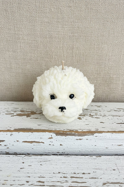 White fluffy dog figurine on a textured surface with a burlap background
