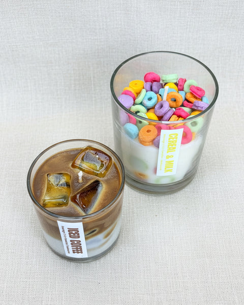 Two glasses of iced coffee with colorful letter-shaped candies on a textured brown background