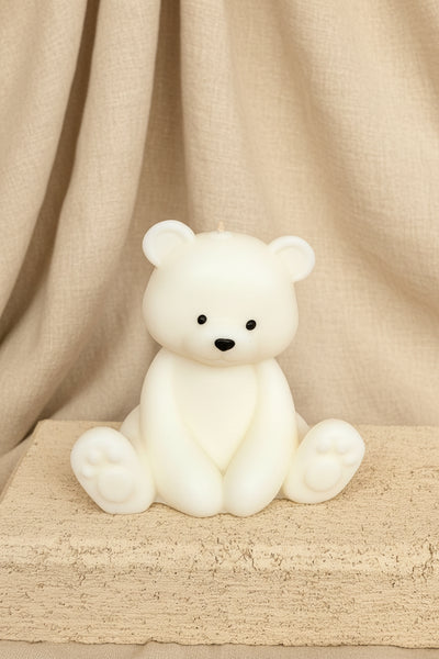 White teddy bear on a textured surface with a burlap background
