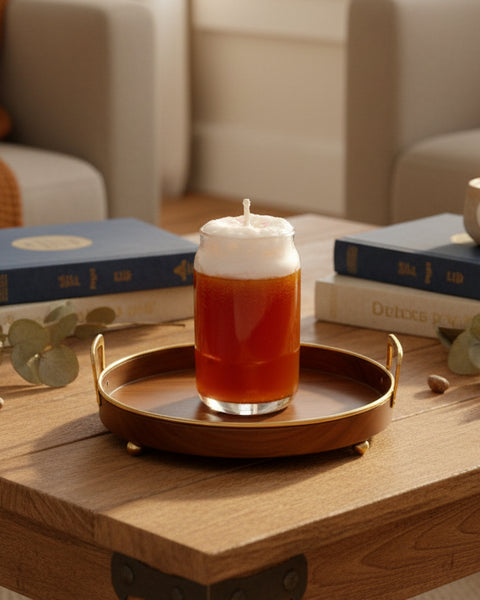 Candle in a glass jar with a white wick on a textured surface and brown background