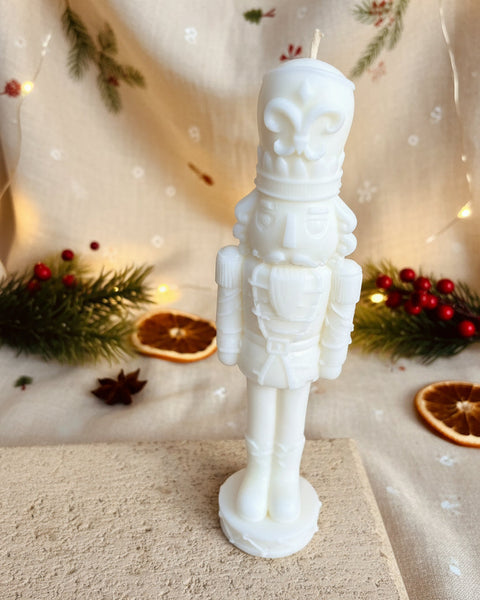 Close-up of a white Christmas Nutcracker soy candle showing detailed sculpted features.