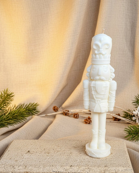 A white sculptural nutcracker soldier soy candle with intricate carved detail, handmade in Melbourne.
