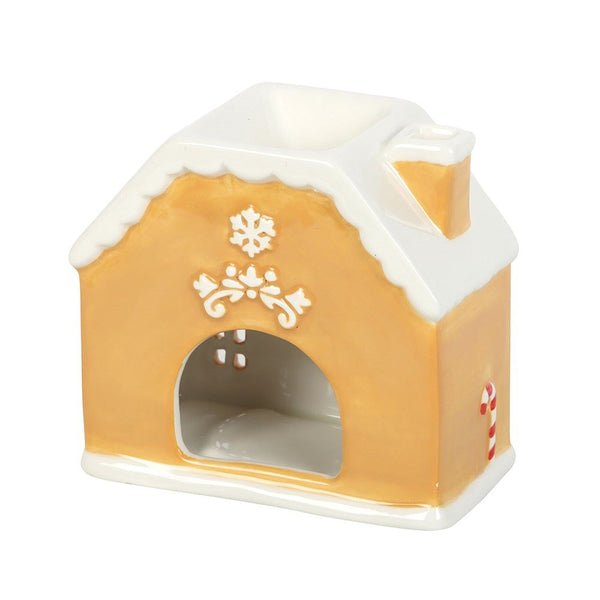 Gingerbread house-shaped candle on a white background