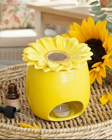 Yellow sunflower-shaped diffuser on a woven surface with a sunflower in the background